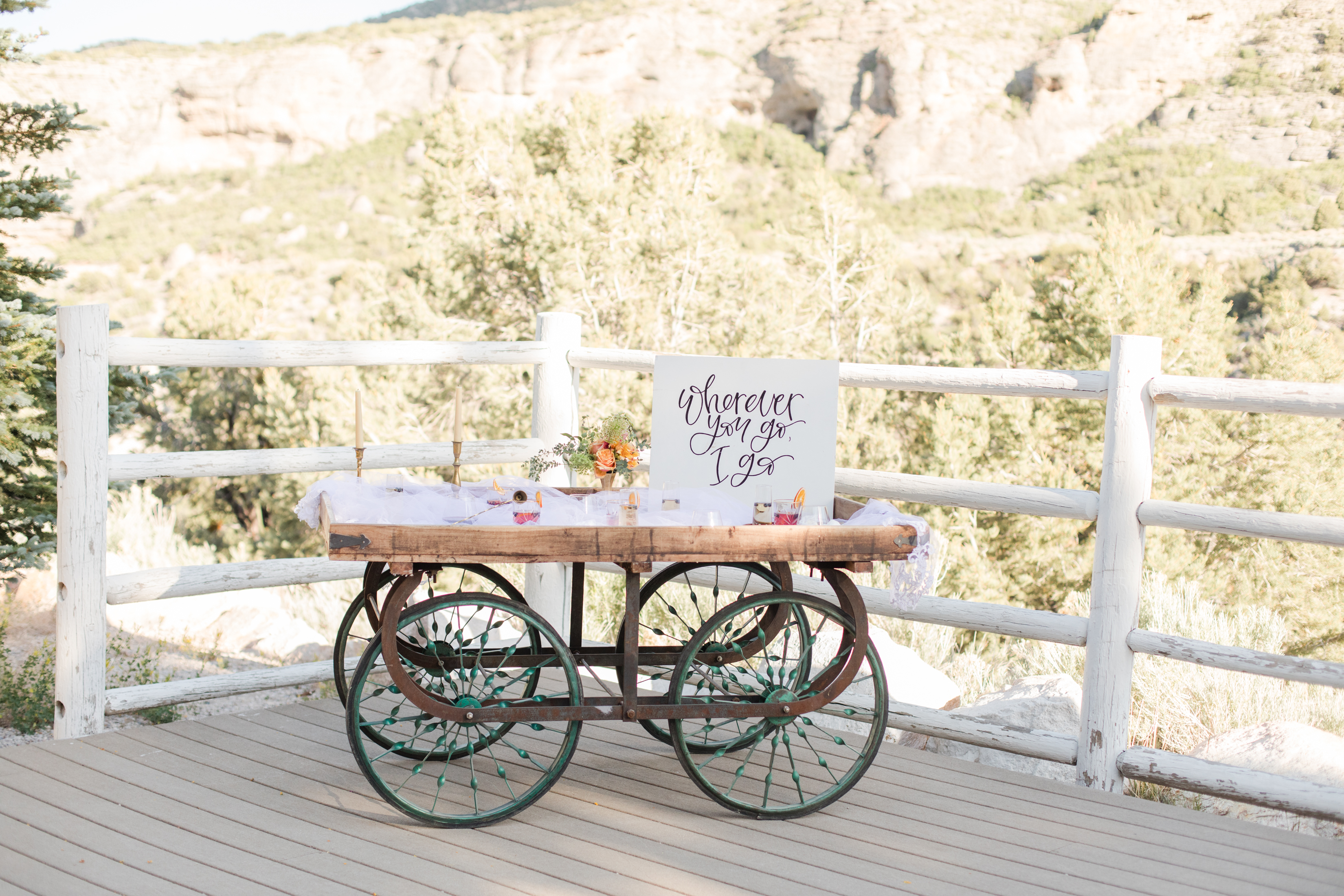 A vintage drink cart with a calligraphy sign at a mountain venue